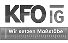 Logo: KFO IG - Wir setzen Maßstäbe. Schrift und Grafik eines Maßstabes (Lineal).