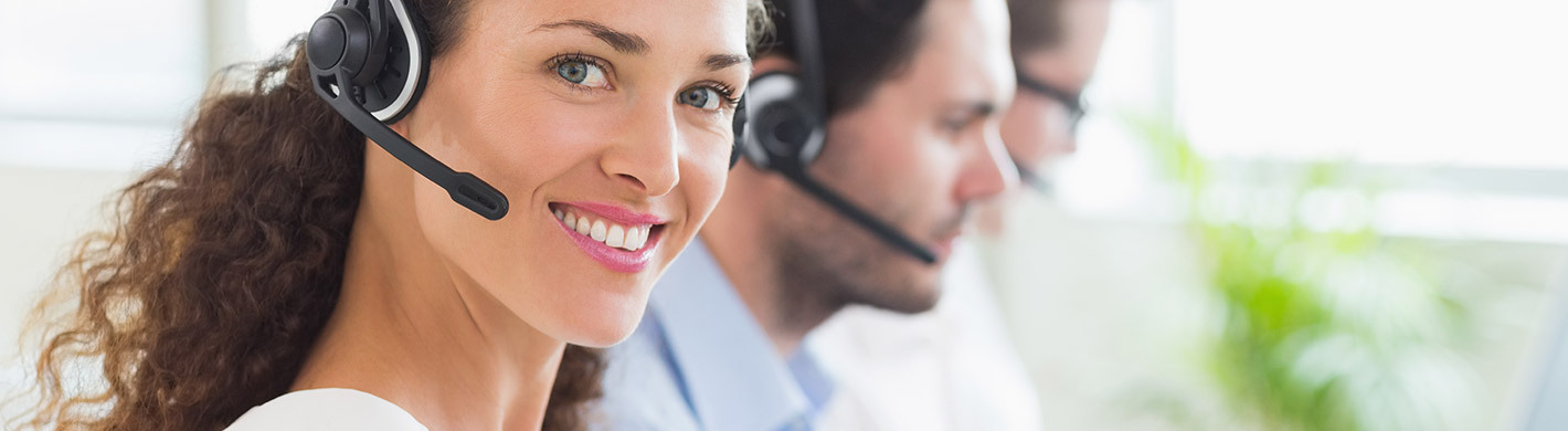 Telefonisten in einem Callcenter mit Headsets, die sich um Kundenkorrespondenz kümmern